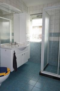 y baño con bañera, lavamanos y ducha. en "Heleen" 6 pers, Lauwersmeer waterfront, full equipped and modern, en Anjum