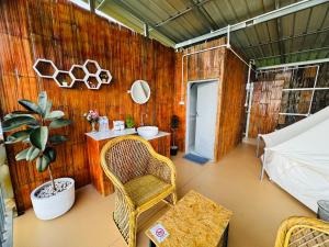 um quarto com uma parede de madeira com uma cadeira e uma mesa em หลงฮักเขาแคมป์ปิ้งภูชี้ฟ้า em Ban Huai Khu