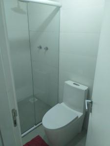 a white bathroom with a shower and a toilet at Apartamento acqua in Pelotas