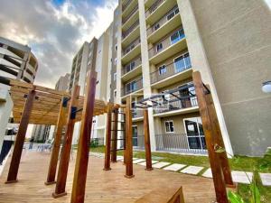 a large building with wooden posts in front of it at Apartamento acqua in Pelotas