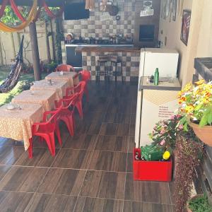 Hostel Santa Luzia في فيكوسا: صف من الطاولات والكراسي الحمراء في المطعم