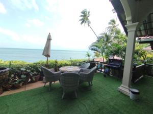 un patio con mesa, sillas y el océano en Le Paradis sur Kos Samui,bang po plage, en Ban Bang Po