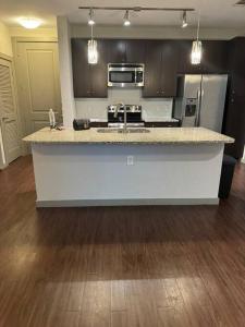 a kitchen with a counter top and a refrigerator at Vacation Rental Home with Pool/Skyline View Near Galleria Mall in Houston