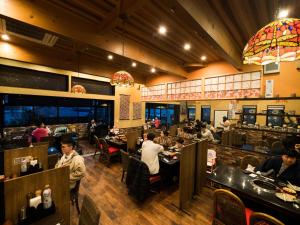 a restaurant with people sitting at tables in a room at Yufuin Lamp no Yado in Yufu