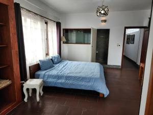 Un dormitorio con una cama con sábanas azules y una mesa. en CHILCHILL Elite Residences BKK2, en Phnom Penh