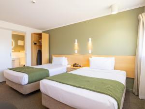 a hotel room with two beds in a room at Auckland Rose Park Hotel in Auckland