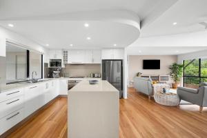a kitchen with white cabinets and a living room at 153 Centenary Heights Rd in Yaroomba