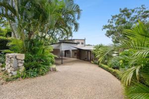 a house with palm trees and a gravel driveway at 153 Centenary Heights Rd in Yaroomba