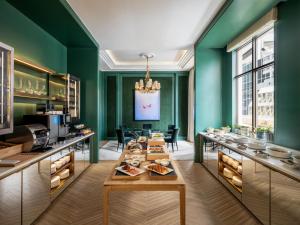 un ristorante con pareti verdi e un tavolo con cibo di Lanson Place Causeway Bay, Hong Kong a Hong Kong