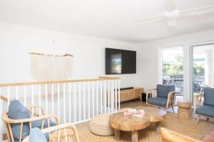 Una sala de estar con sillas azules y una mesa. en Little Birdie, en Kingscliff
