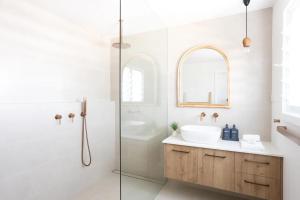 Un baño blanco con lavabo y ducha. en Little Birdie, en Kingscliff 27 fotos más
