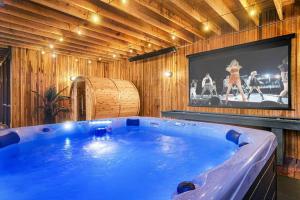 Longhaus: Modern Minimalist Luxury Home: Firepit, outdoor kitchen, pets في Mars Hill: حوض أزرق كبير في غرفة مع تلفزيون