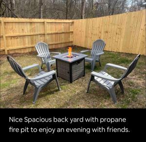 three chairs and a table with a fire pit to enjoy an evening with friends at NEW Luxury Home Downtown Pet Friendly Fenced Yard in Chattanooga