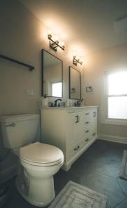 埃姆赫斯特的住宿－Charming Modern Home!，一间带卫生间、水槽和镜子的浴室