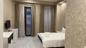Cette chambre comprend un lit et une salle de bains. dans l'établissement Astoria Hotel, à Zugdidi