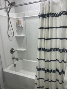 a bathroom with a shower curtain next to a bath tub at NEW Luxury Home Downtown Pet Friendly Fenced Yard in Chattanooga
