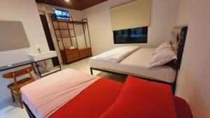 a bedroom with two beds and a sink and a mirror at Batik Inn Semarang in Semarang