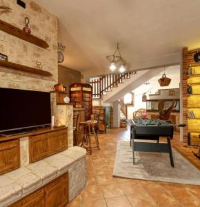 een woonkamer met een tv en een pooltafel bij G&S Rustic House in San Pancrazio Salentino