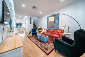 a living room with a red couch and blue chairs at Kashida - Persian-Style Townhouse with Office in Marion