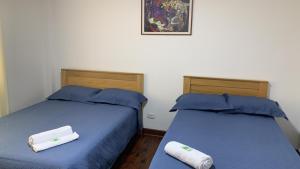 dos camas sentadas una al lado de la otra en una habitación en Lindo depa san miguel, 3camas, wifi, terraza., en Lima