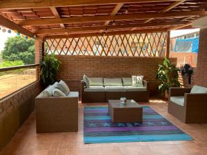 un patio con sofás y mesas en una pared de ladrillo en Lindo depa san miguel, 3camas, wifi, terraza., en Lima