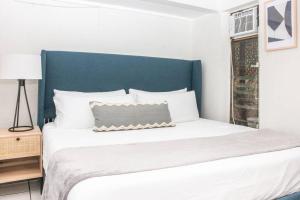 um quarto com uma cama grande e uma cabeceira azul em Sea View & Sunset Haven em Enighed