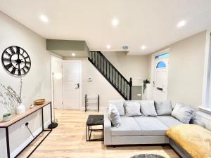 a living room with a white couch and a staircase at The Keyfield House - St Albans in Saint Albans