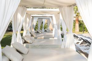 a row of white beds with pillows at Cala Millor Garden Hotel - Adults Only in Cala Millor