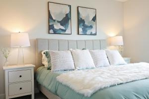 - un lit avec une couette blanche et 2 lampes dans l'établissement Stylish Home with 3 King Beds,Garage,Disney+, à Edmonton