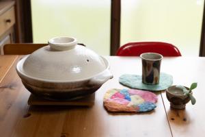 a table with a tea pot and a cookie on it at 【湯布院の山小屋】サンクラウド・ヒュッテ in Yufuin