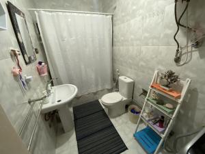 a white bathroom with a sink and a toilet at Azur 5 Stars Cozy room in Cairo