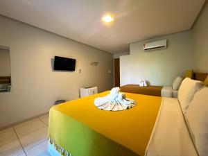 um quarto de hotel com uma cama com uma toalha em Pousada Unaí em Porto de Galinhas