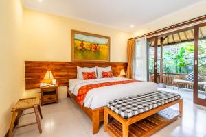 a bedroom with a bed and a large window at Meruhdani Boutique Hotel Ubud in Ubud