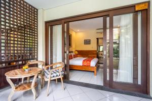 a bedroom with a bed and a table and chairs at Meruhdani Boutique Hotel Ubud in Ubud
