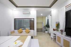 Habitación con cama, sofá y TV. en Lis Hotel en Da Nang