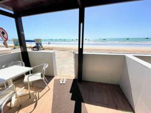 a view of the beach from a restaurant with a table and chairs at Apê 1: Pé na Areia Maragogi - O Caribe Brasileiro in Maragogi
