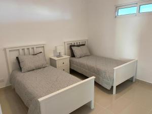 a bedroom with two beds and a window at Villa parmera in Los Corrales
