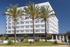 a hotel with palm trees in front of it at Cala Millor Garden Hotel - Adults Only in Cala Millor