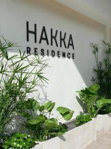 a sign for haikkaresurance in a room with plants at HAKKA Wellness Residence in Samut Songkhram