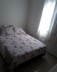 - une chambre dotée d'un lit avec une couverture rouge et blanche dans l'établissement Alojamentos Rio Verde, à Rio Verde