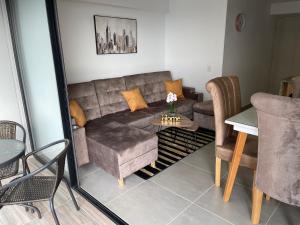 un soggiorno con un divano e un tavolo di Acogedor apartamento cerca de clínica en F/blanca a Floridablanca