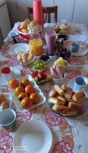 - une table avec des assiettes de nourriture et des fruits dans l'établissement Alojamentos Rio Verde, à Rio Verde