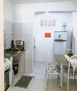 La cuisine est équipée d'une table, de chaises et d'un réfrigérateur. dans l'établissement Alojamentos Rio Verde, à Rio Verde