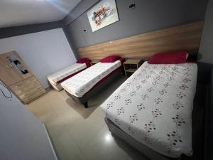 two beds in a small room with at Hostal America in Calama