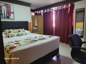 une chambre d'hôtel avec un lit et une chaise dans l'établissement Hostal America, à Calama