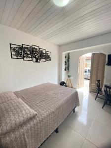 a white bedroom with a bed and a table at Suite Brava in Búzios