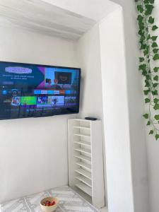 a flat screen tv hanging on a white wall at Suite Brava in Búzios