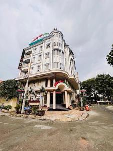 ein großes weißes Gebäude an der Ecke einer Straße in der Unterkunft khách sạn Hồng Tâm in Ho-Chi-Minh-Stadt