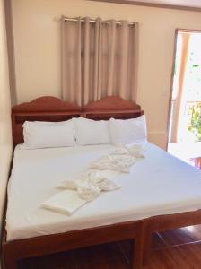 a bed with white sheets and white towels on it at Nature Seaview in Saavedra