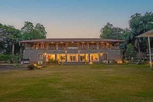 a large brick house with a lawn in front of it at amã Stays & Trails Butterfly Villa, Deolali, Nashik in Nashik